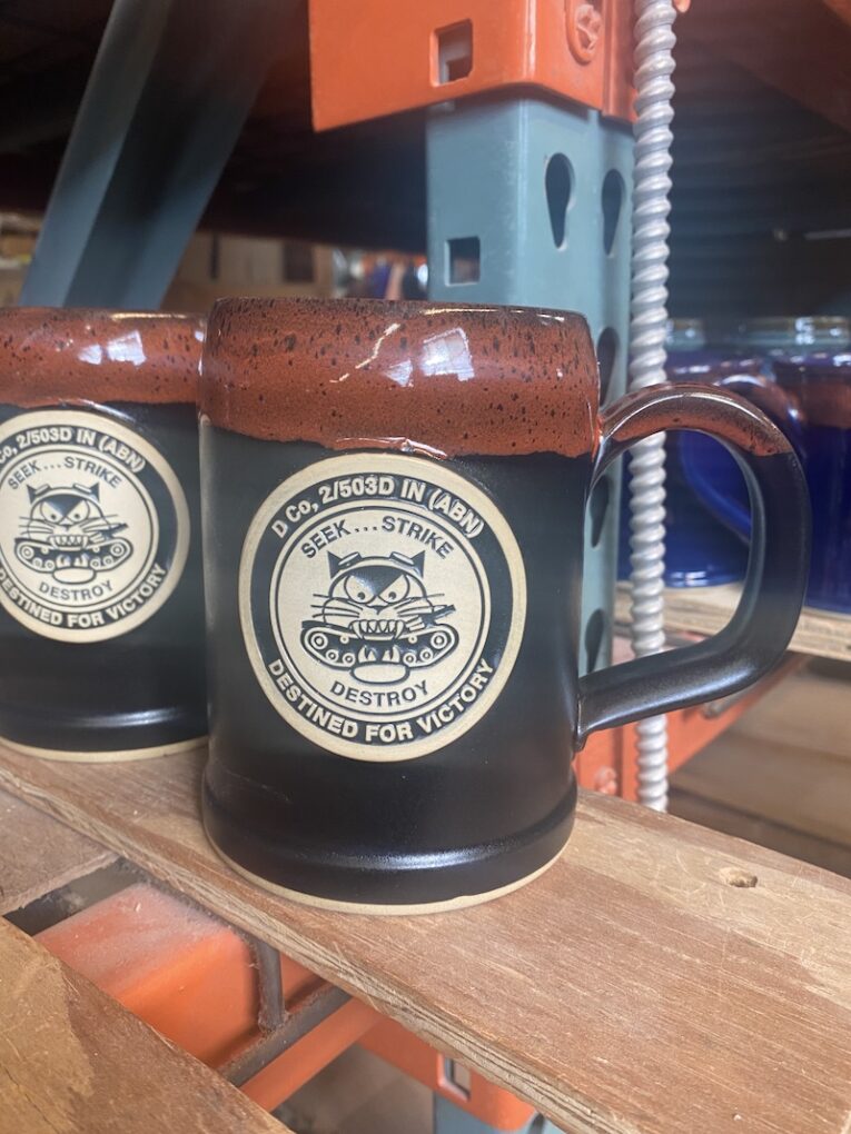 Black beer stein with military emblem.