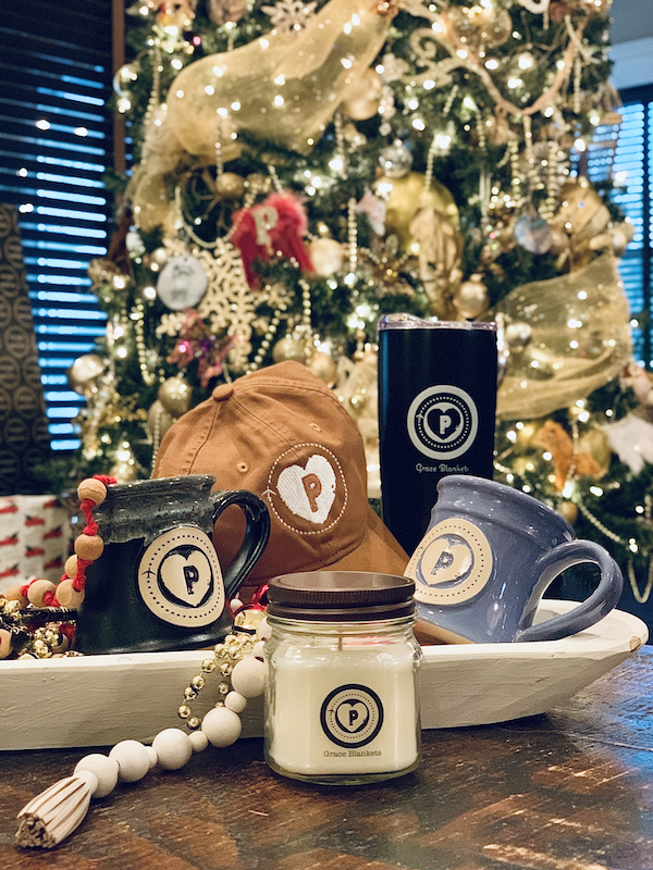 Collection of logo branded items sitting on a table with a christmas tree in the background.